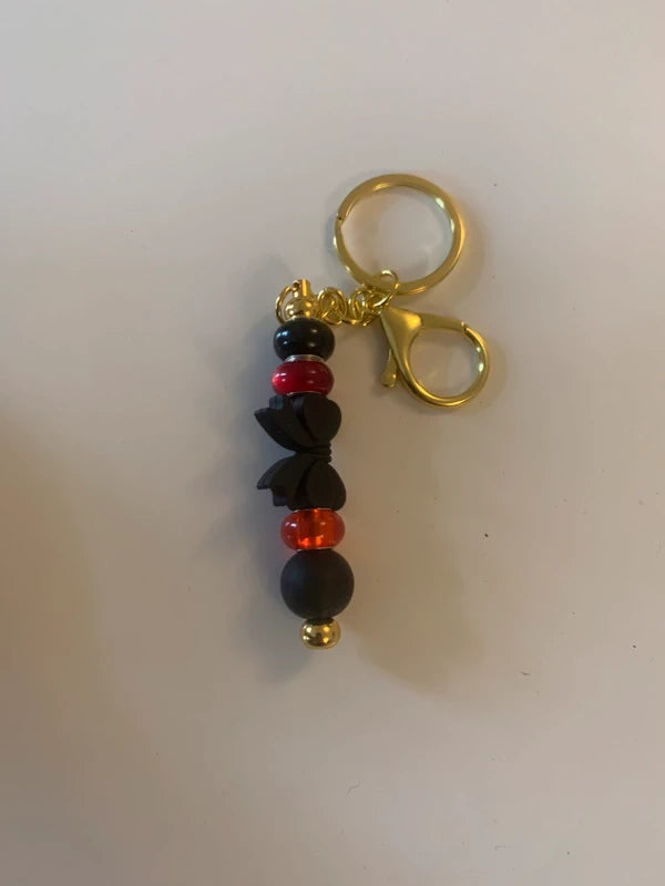 Bijou de sac artisanal porte clé doré gros noeud noir perle silicone verre rouge accessoire chic