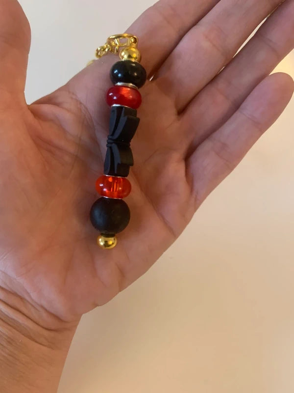 Bijou de sac artisanal porte clé doré gros noeud noir perle silicone verre rouge accessoire chic