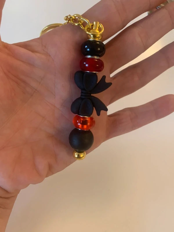 Bijou de sac artisanal porte clé doré gros noeud noir perle silicone verre rouge accessoire chic