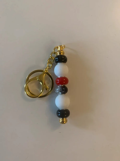 Bijou de sac artisanal porte clé doré perle silicone verre rouge noire brillant élégant chic