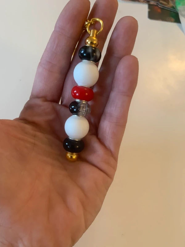 Bijou de sac artisanal porte clé doré perle silicone verre rouge noire brillant élégant chic