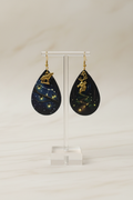 Boucles d’oreilles lucioles loup et cerf sur présentoir ivoire