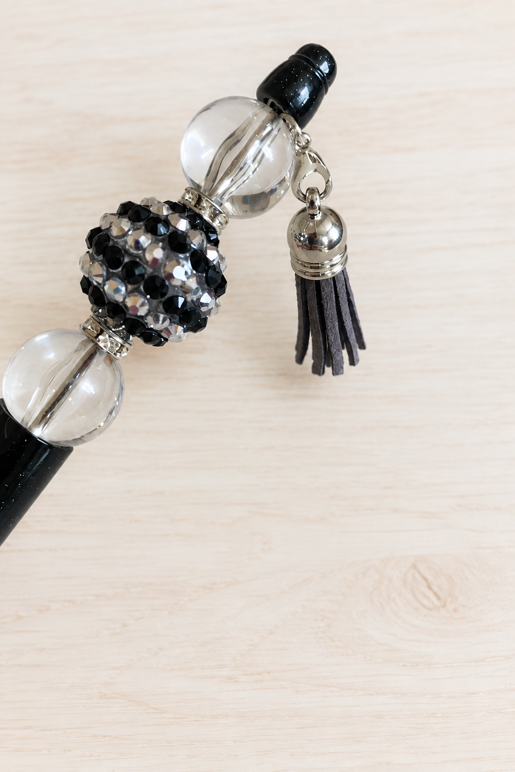 Stylo noir pailleté à perle transparente et pompon
