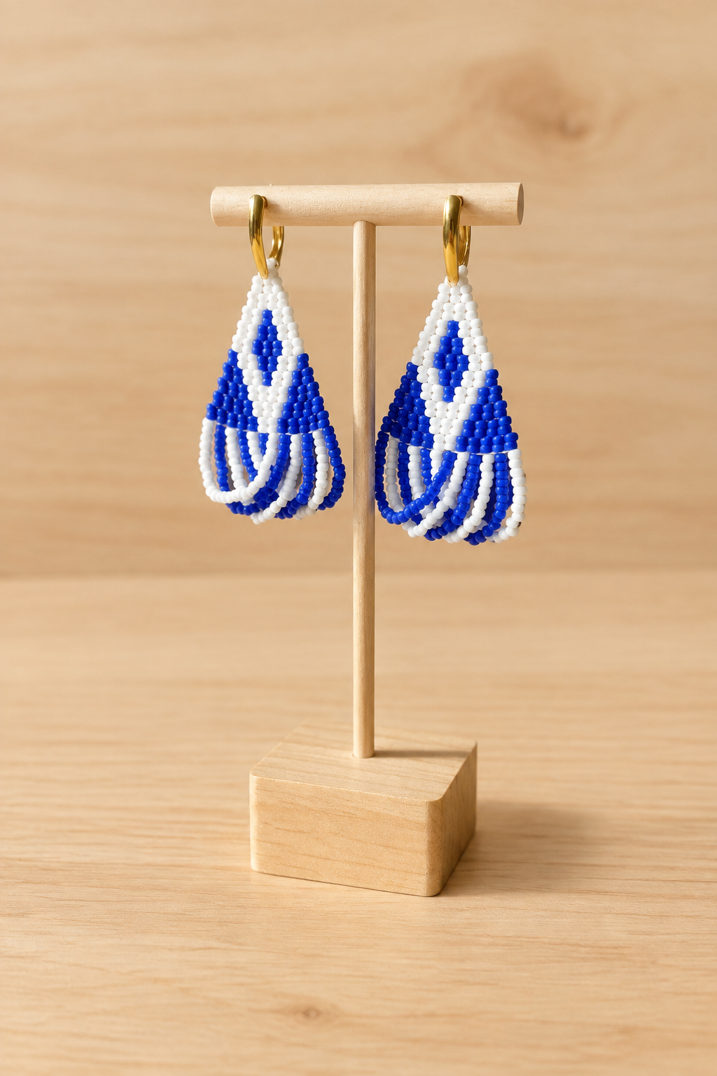 Boucles d’oreilles Miyuki blanches et bleu marine sur fond bois clair avec présentoir