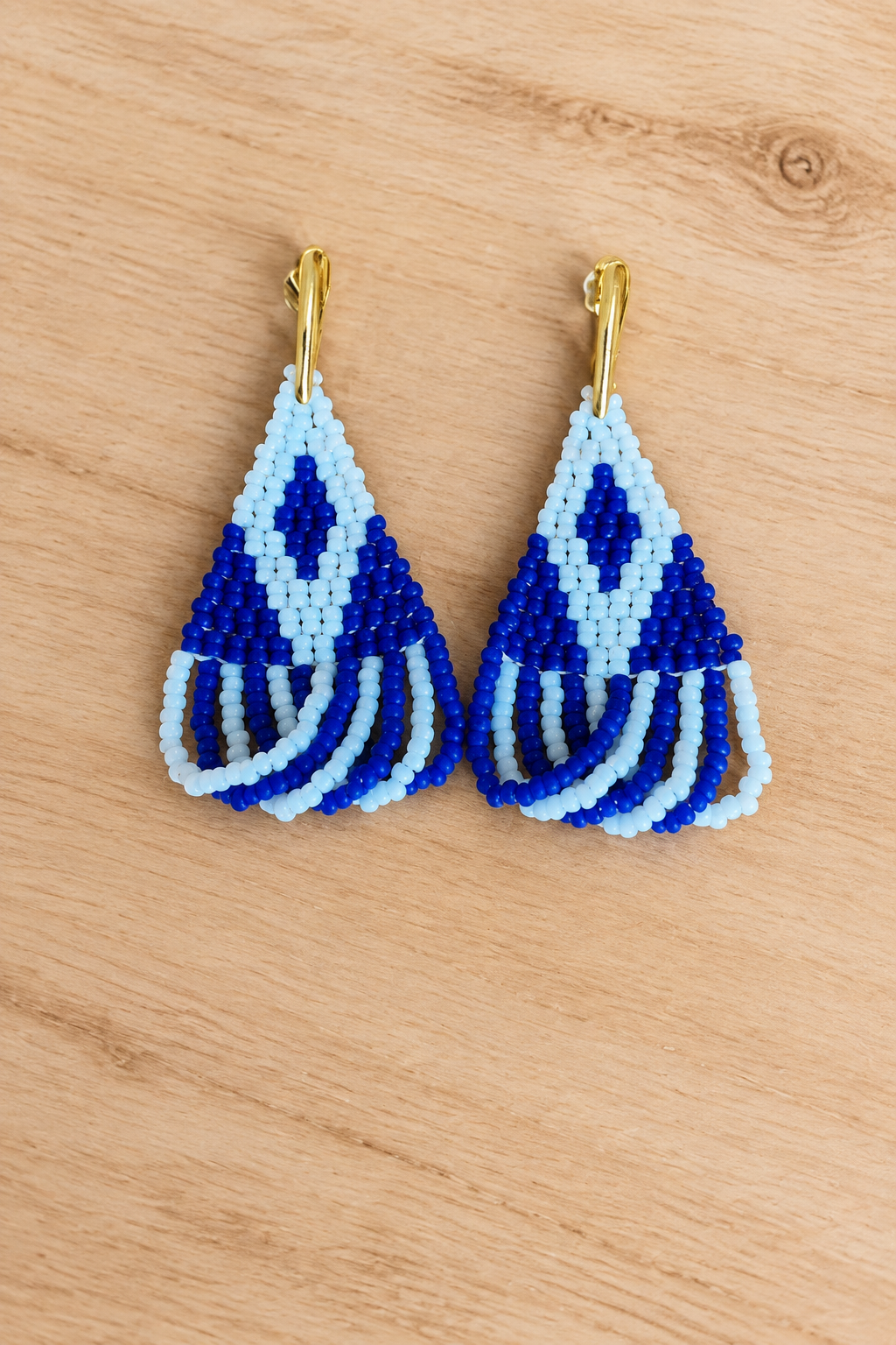 Boucles d’oreilles Miyuki blanches et bleu marine sur fond bois clair