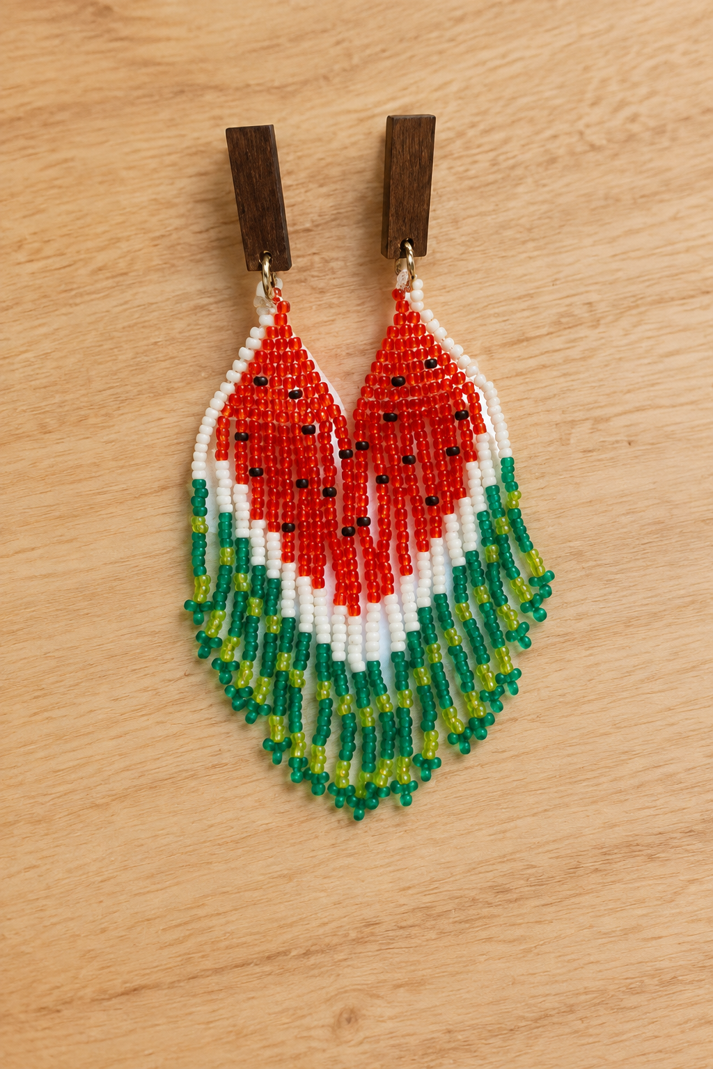 Boucles d’oreilles Miyuki pastèque rouge et vert sur fond bois clair