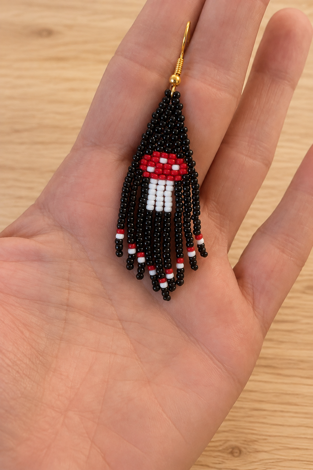 Boucle d’oreille pendante noire en perles Miyuki sur fond bois clair
