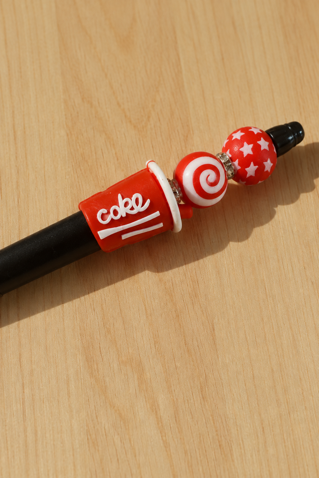 Détail du stylo soda cola rouge et noir sur bois clair