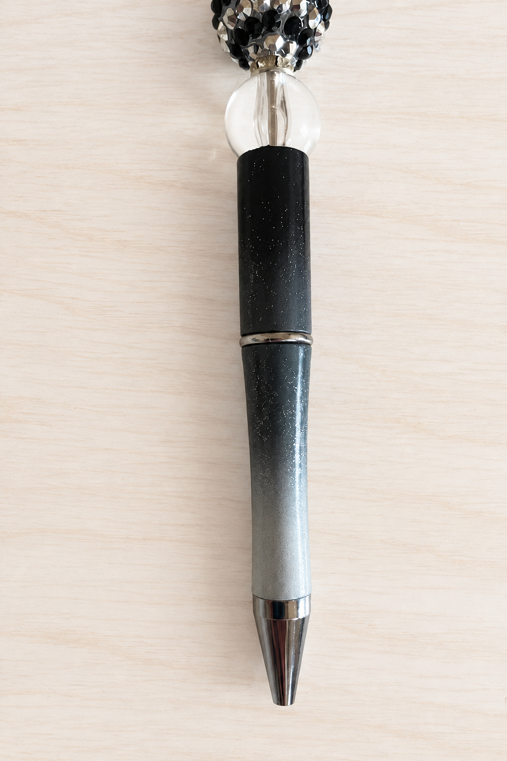 Stylo noir pailleté à perle transparente et pompon