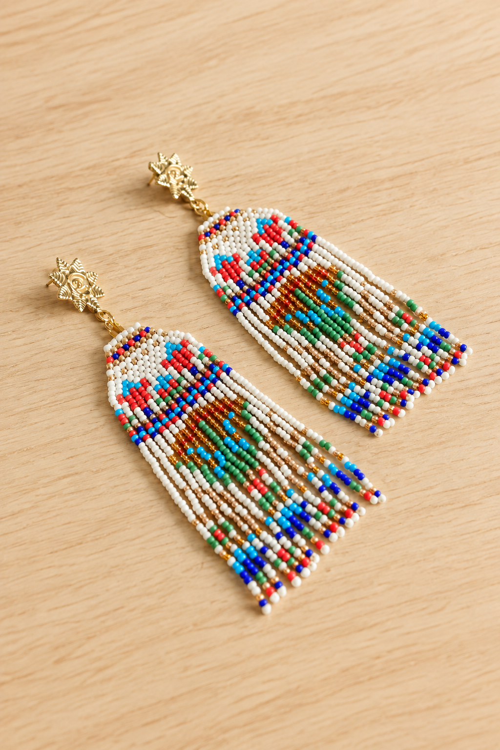 Boucles d’oreilles longues Lotus égyptien en perles Miyuki sur fond bois clair