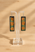 Photo de présentation des boucles d’oreilles en bois peint roses orangées sur présentoir