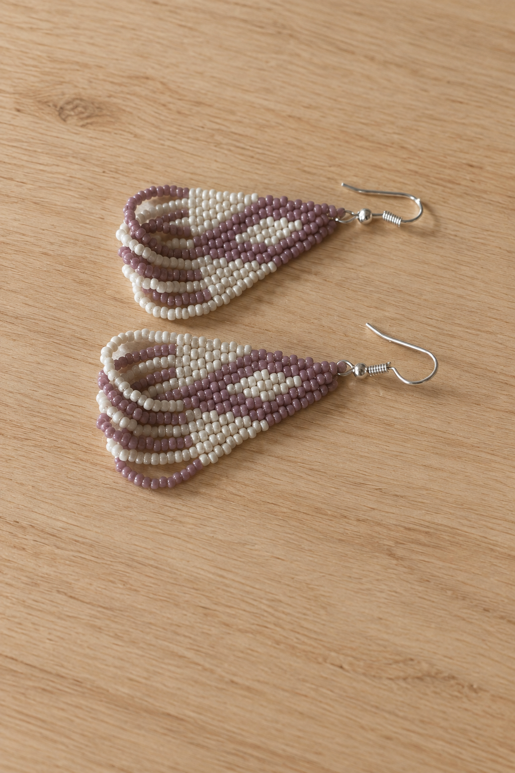 Boucles d’oreilles triangle crème mauve lilas sur fond bois clair