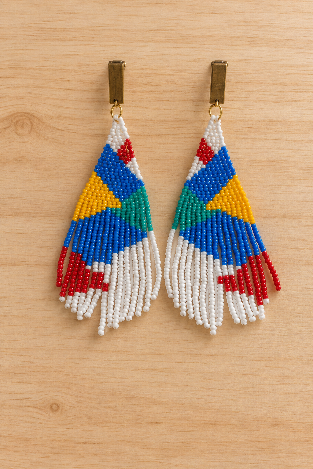 Boucles d’oreilles pendantes géométriques mauve et multicolores en perles Miyuki sur fond bois clair