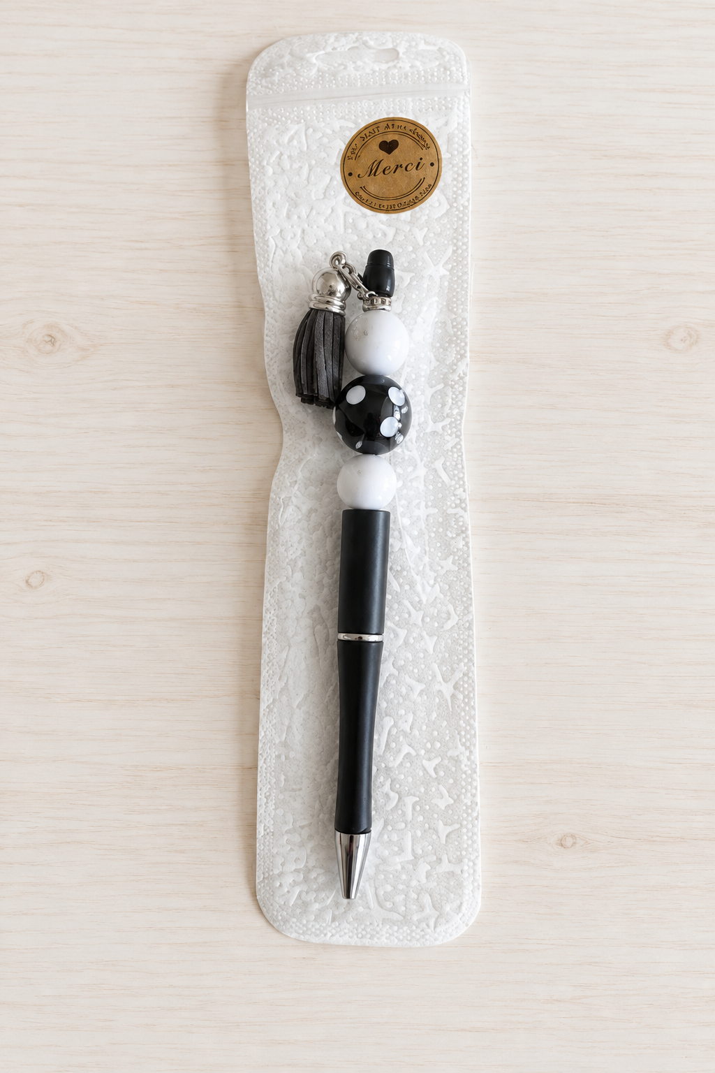 Stylo noir à pois et pompon à strass blancs