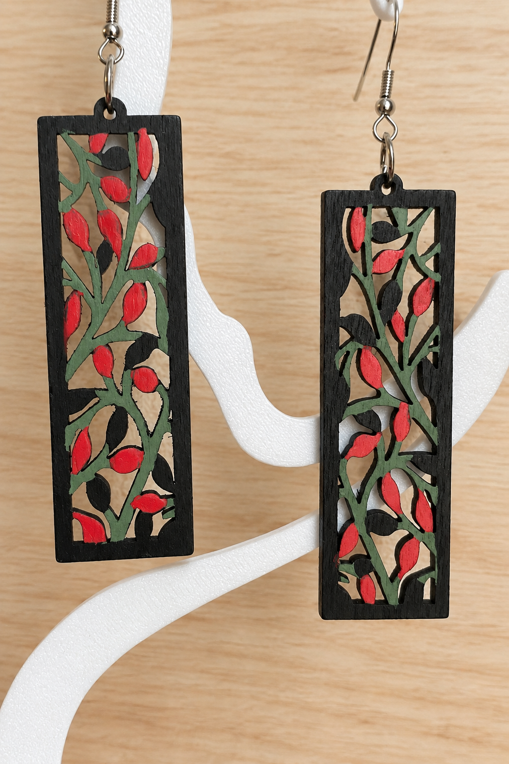 Boucles d’oreilles en bois peint branches et baies rouges sur présentoir