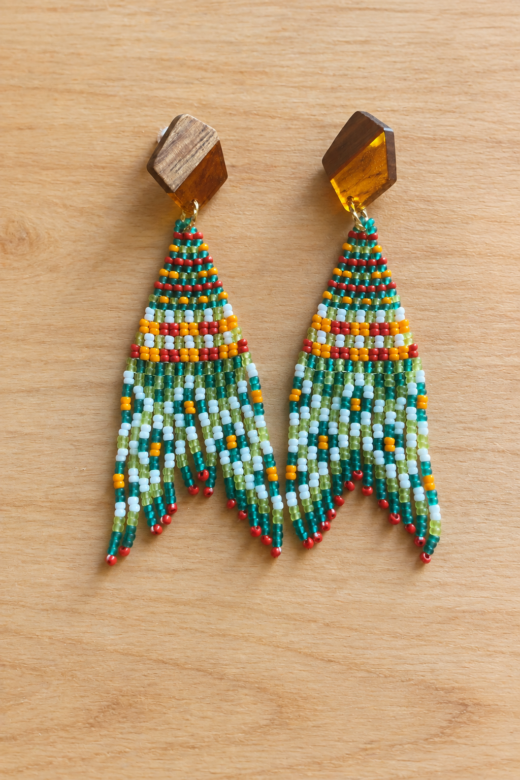Boucles d’oreilles Miyuki melon pastèque et petite croix orange sur fond bois clair