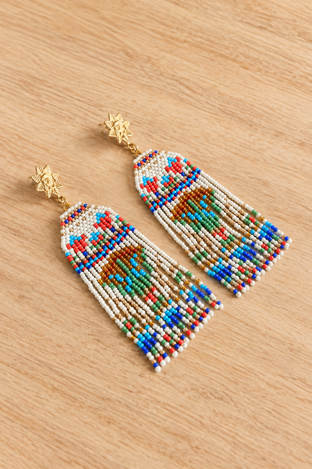 Boucles d’oreilles longues Lotus égyptien en perles Miyuki sur fond bois clair