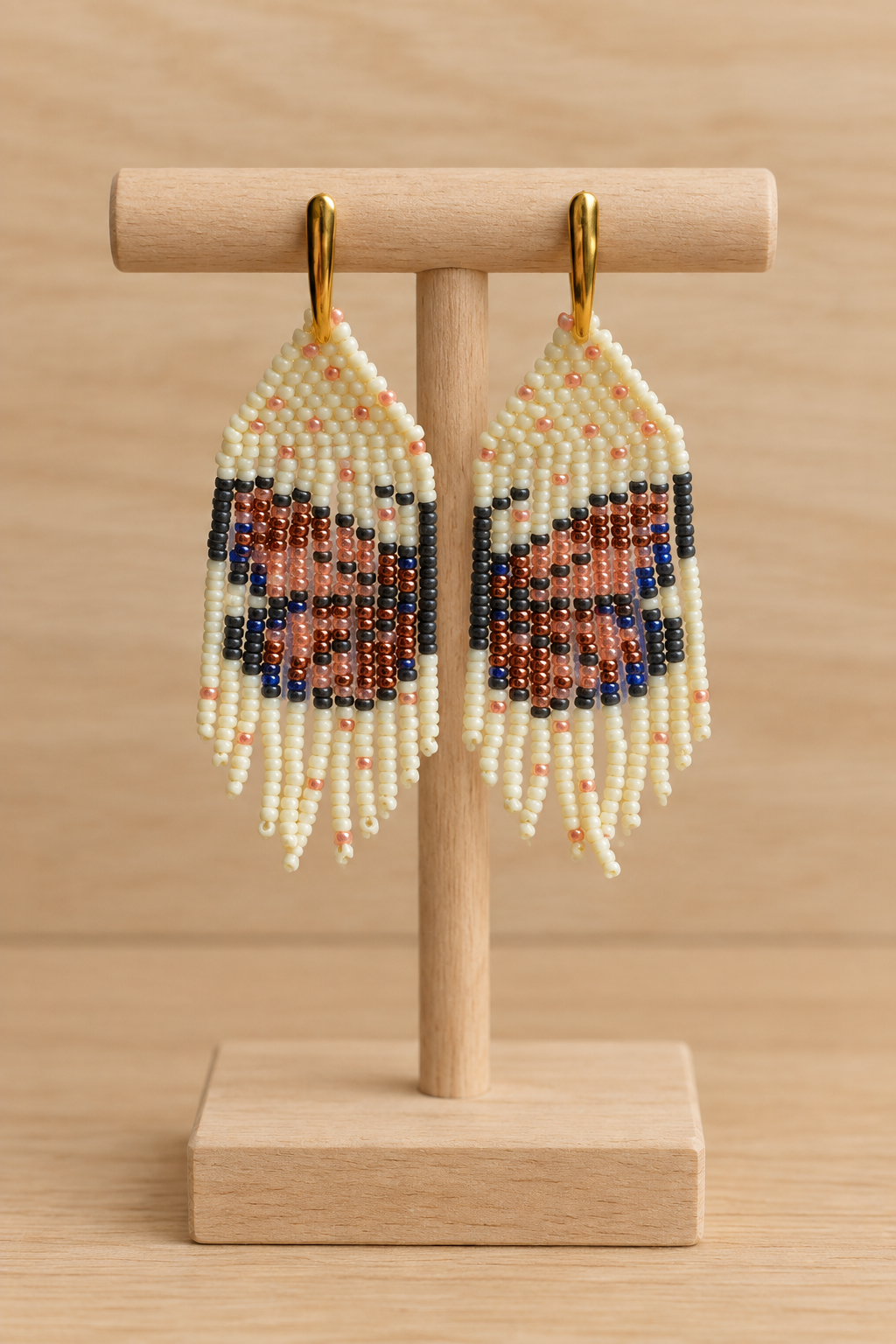 Boucles d’oreilles papillon Miyuki sur présentoir en bois clair