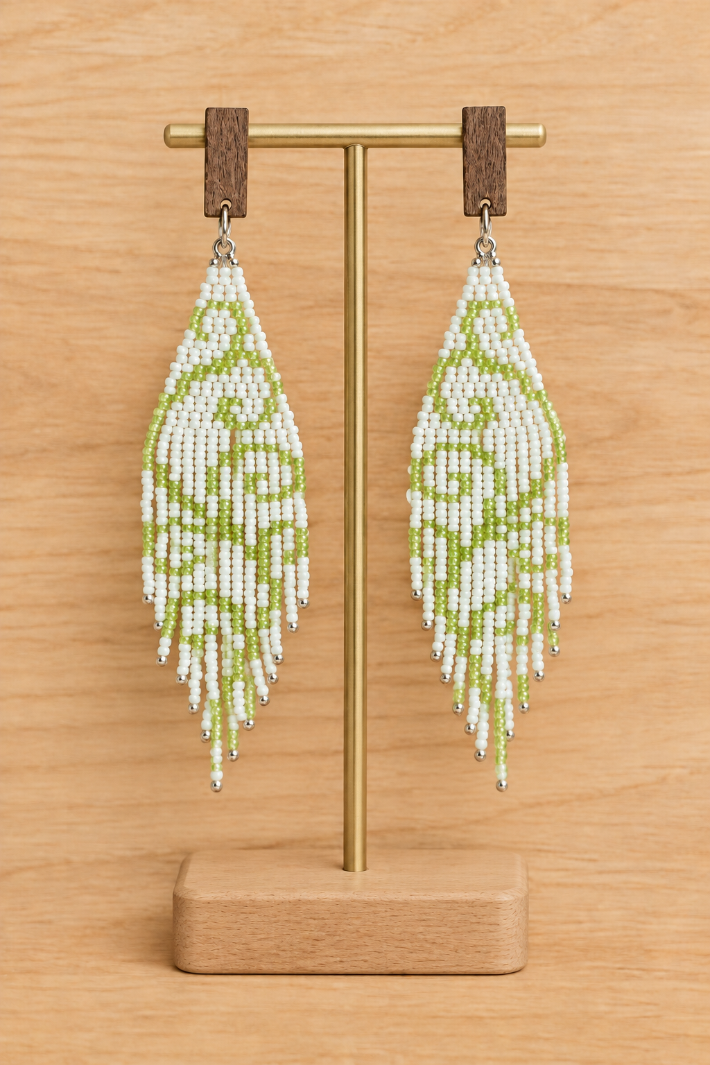 Boucles d’oreilles pendantes vert clair en perles Miyuki présentées sur un présentoir, sur fond bois clair