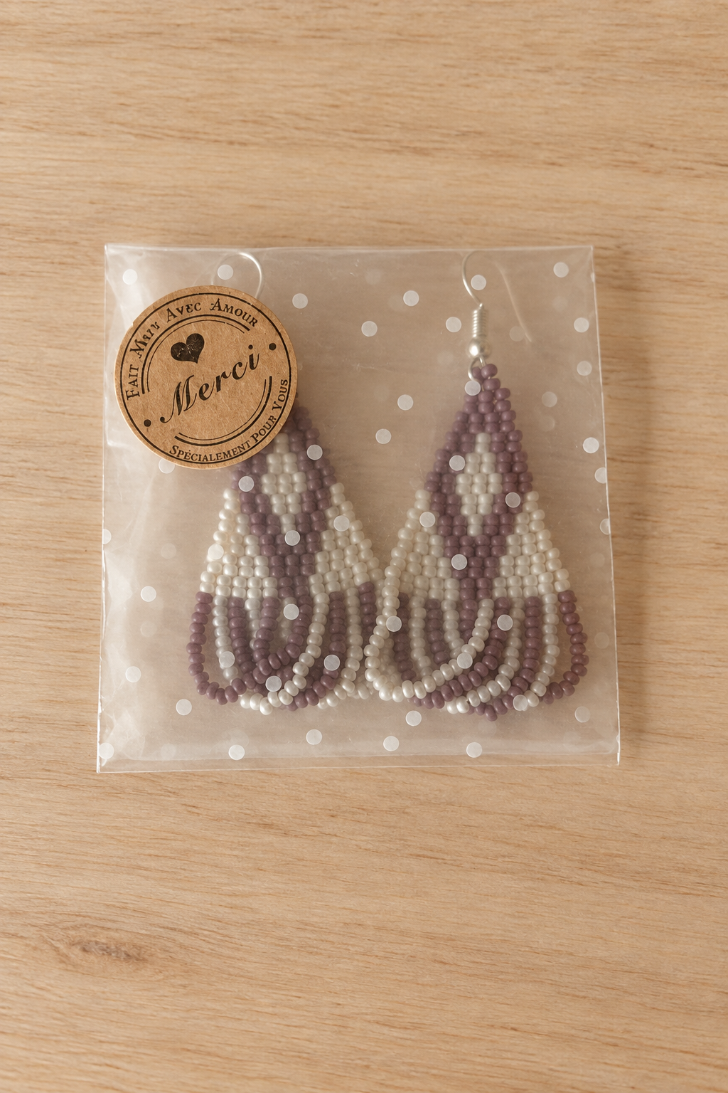 Boucles d’oreilles triangle crème mauve lilas sur fond bois clair