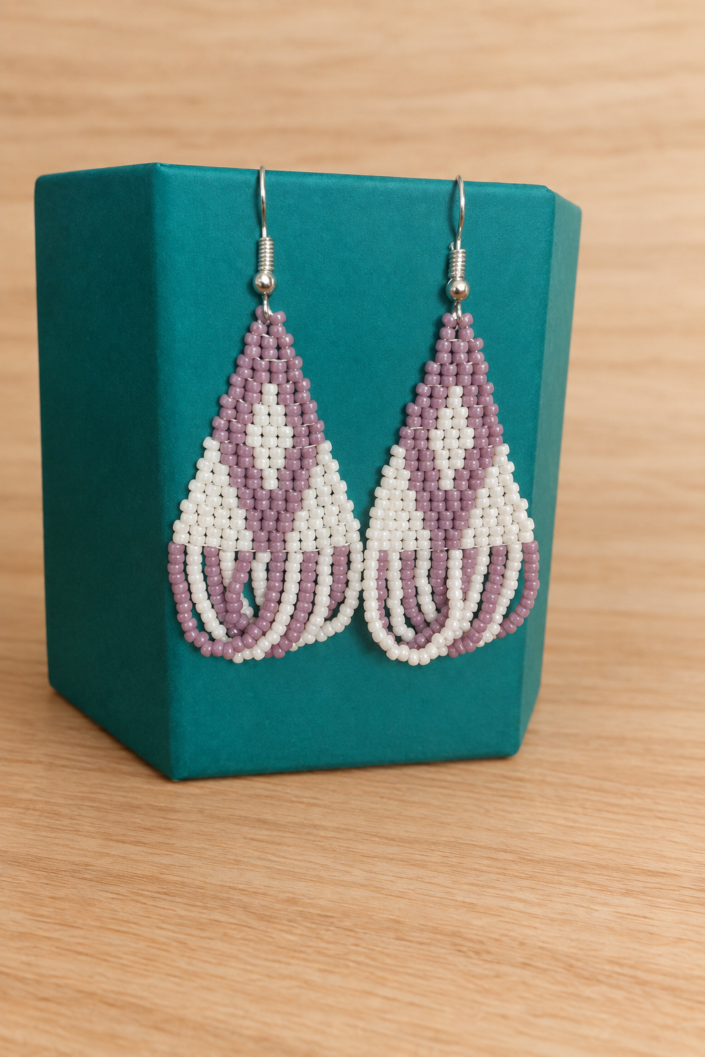 Boucles d’oreilles triangle crème mauve lilas sur présentoir, fond bois clair