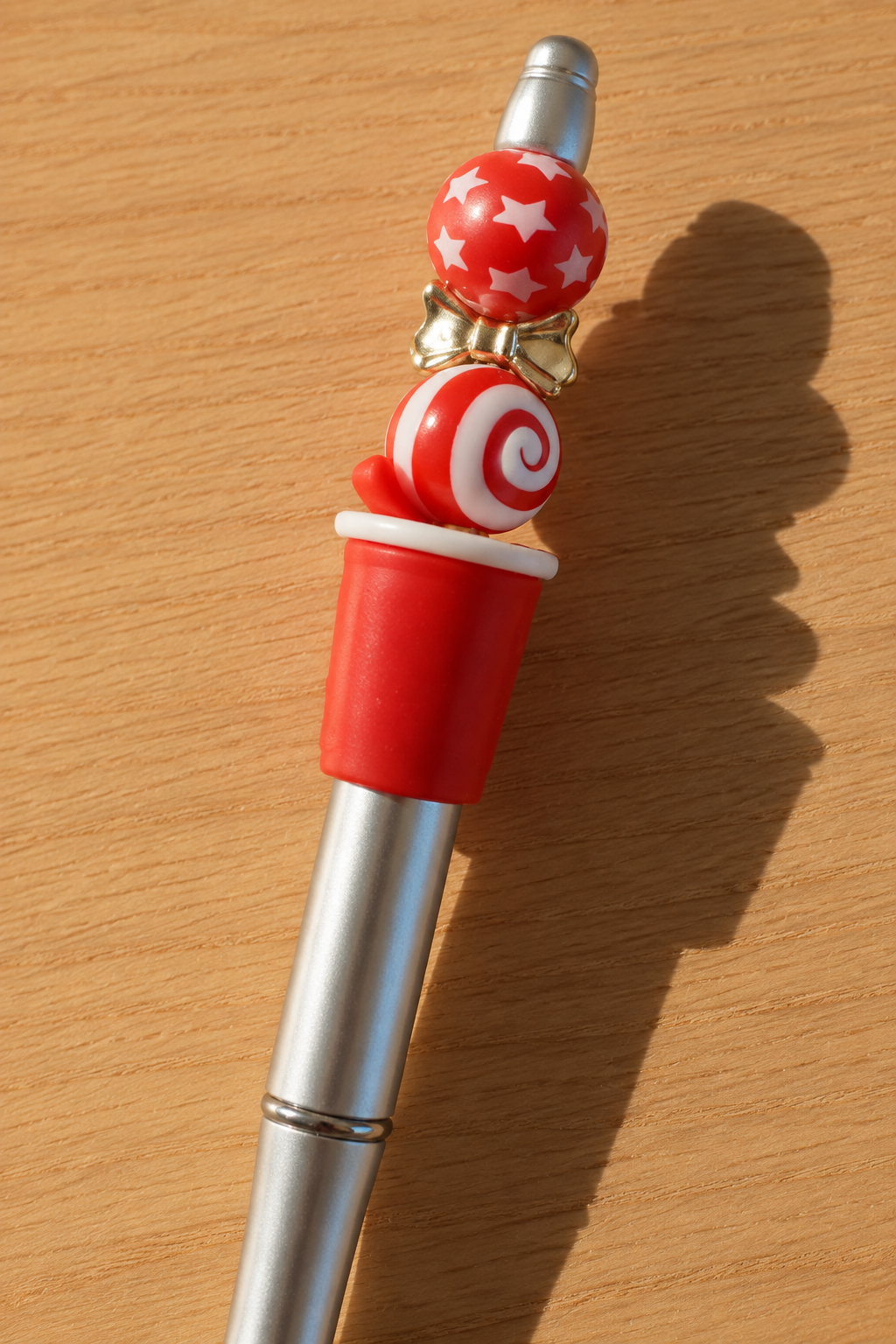 Vue arrière des perles du stylo cola argenté sur bois clair