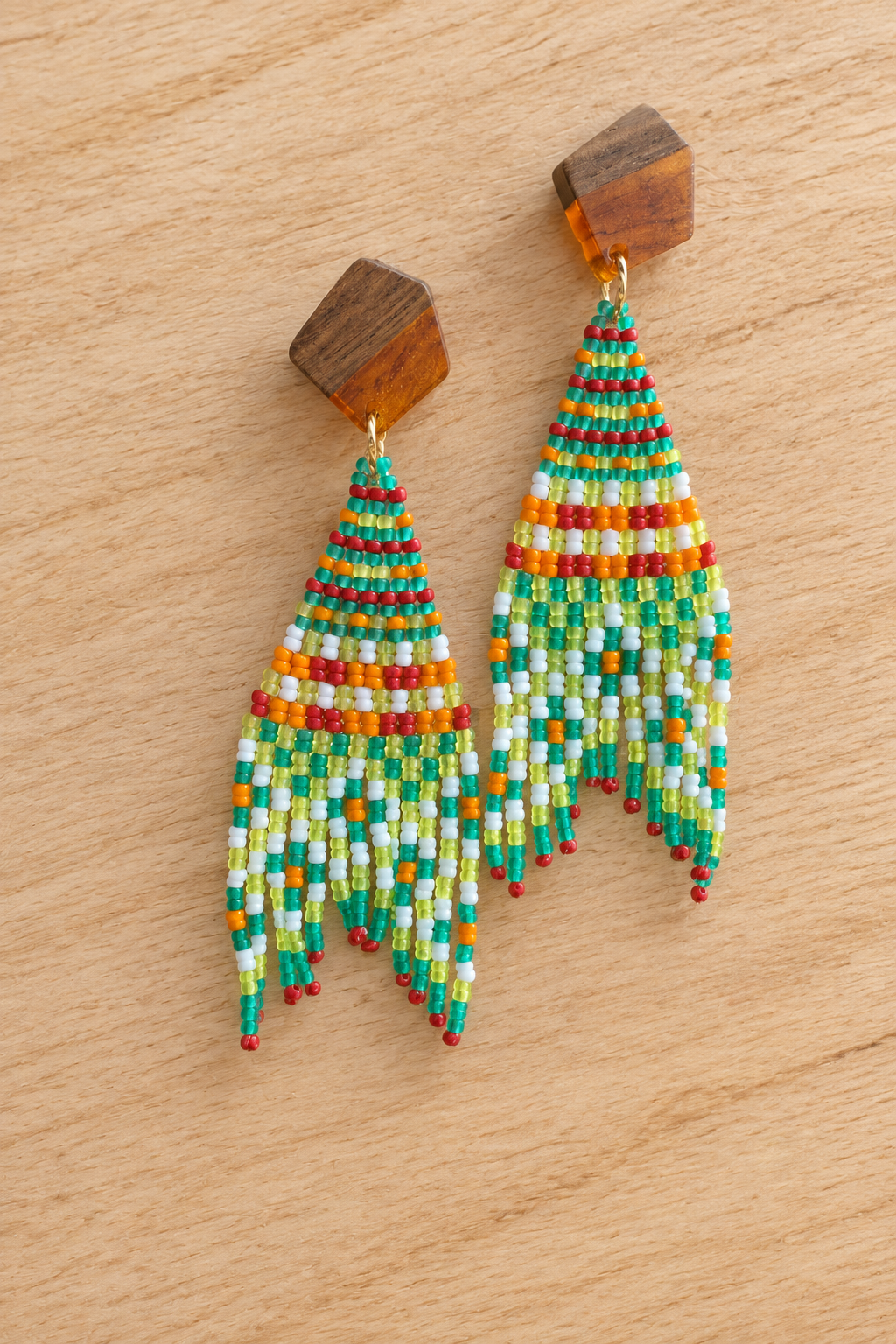 Boucles d’oreilles Miyuki melon pastèque et petite croix orange sur fond bois clair