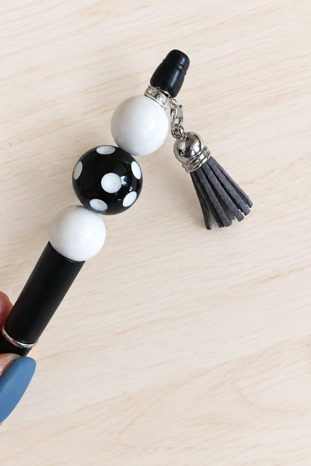 Stylo noir à pois et pompon à strass blancs