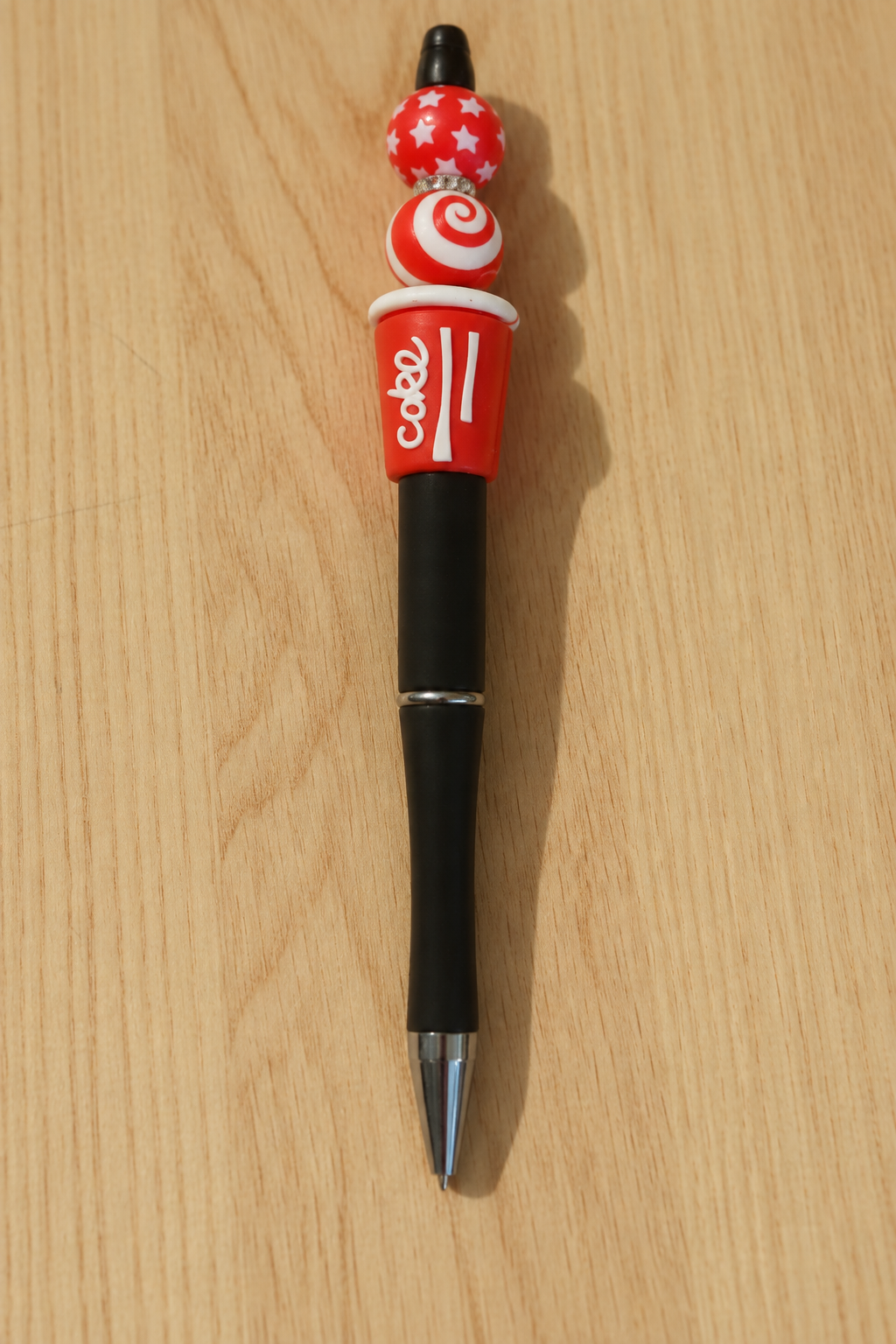 Stylo soda cola rouge et noir à strass sur bois clair