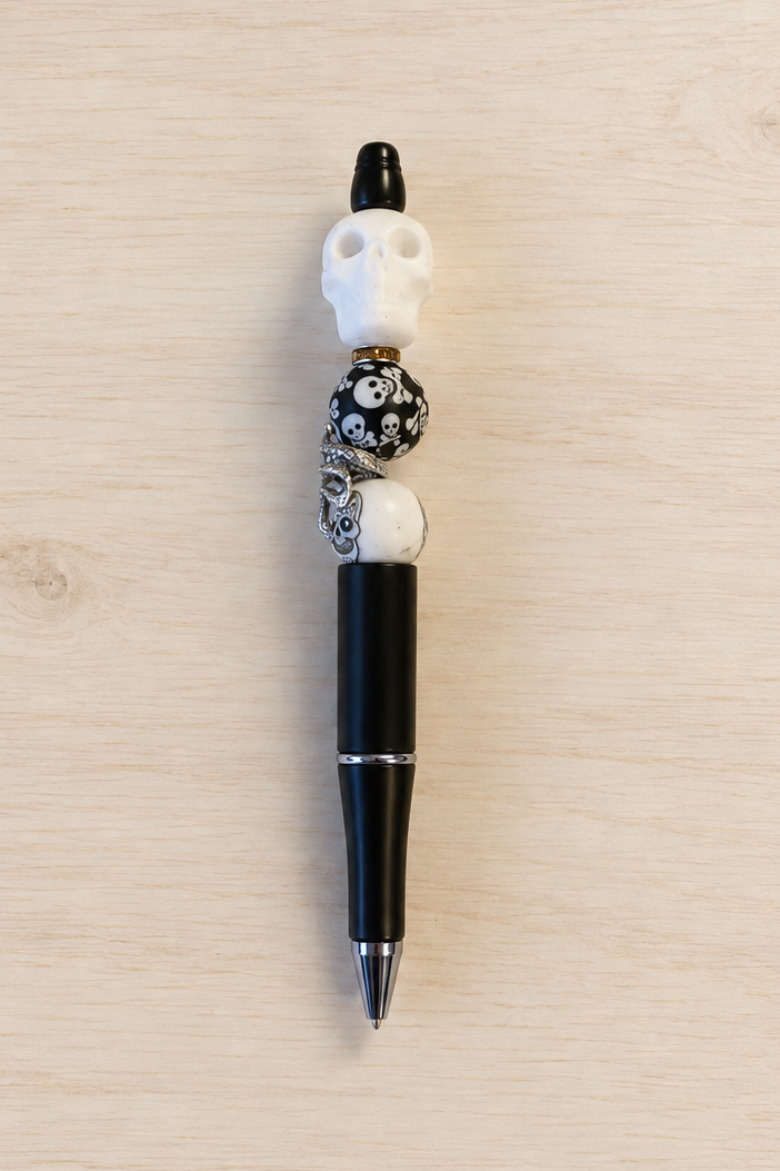 Stylo crâne et serpent à strass, vue complète sur fond bois clair