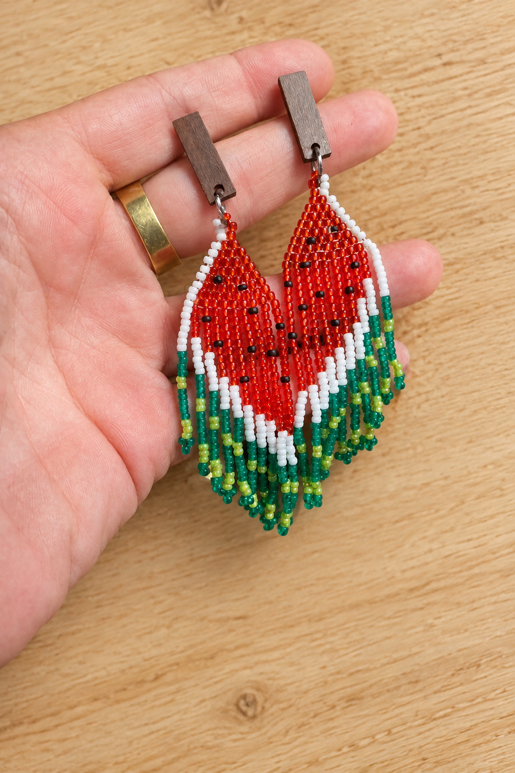Boucles d’oreilles Miyuki pastèque rouge et vert sur fond bois clair