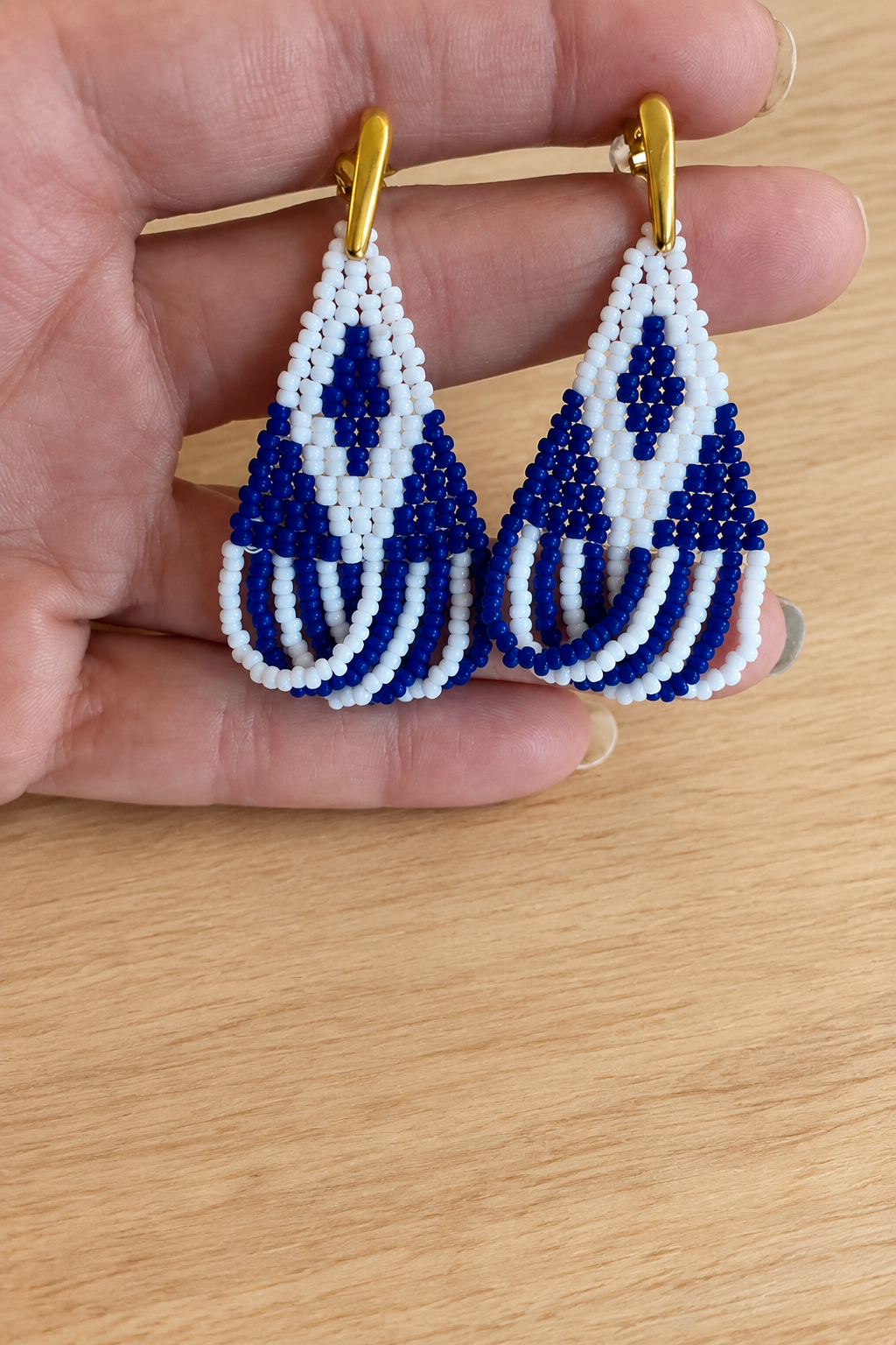 Boucles d’oreilles Miyuki blanches et bleu marine présentées sur fond bois clair