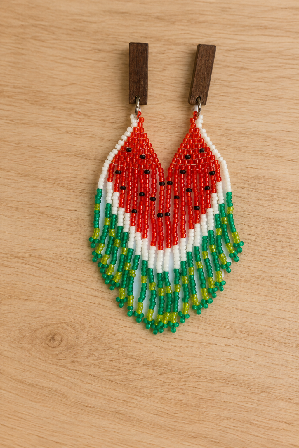 Boucles d’oreilles Miyuki pastèque rouge et vert sur fond bois clair