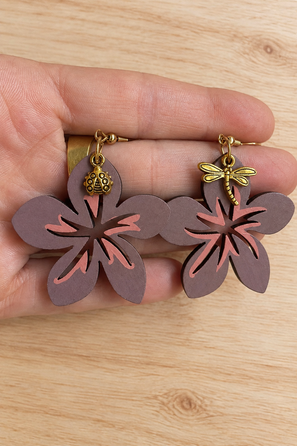 Boucles d’oreilles fleur hibiscus en bois peint sur fond bois clair