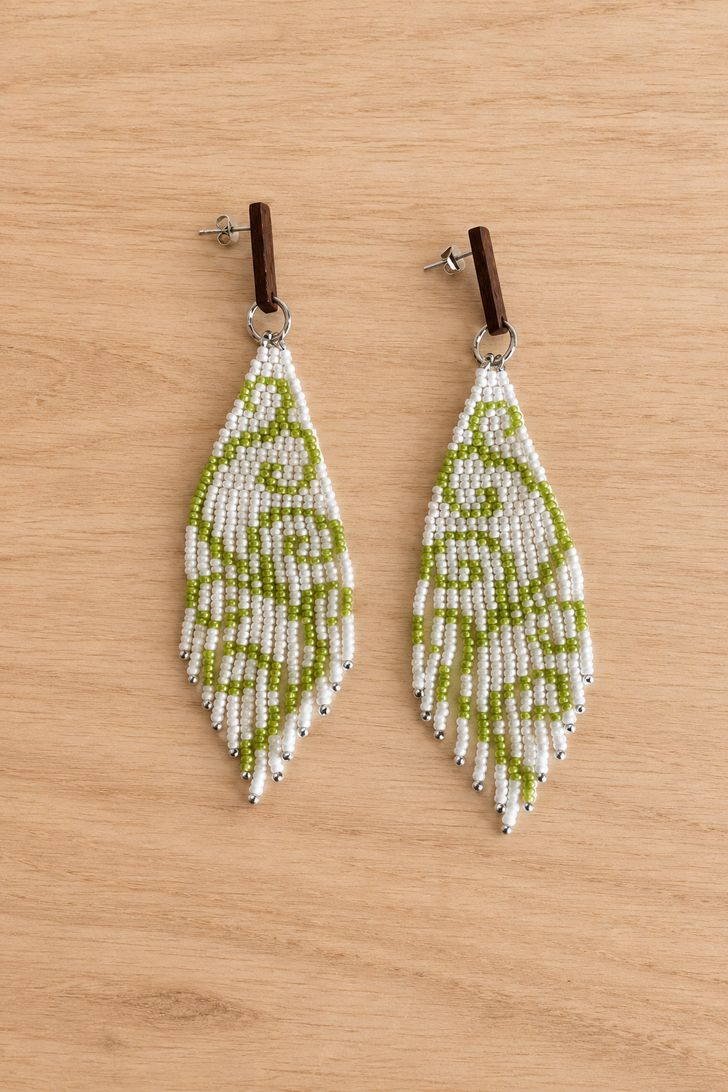 Boucles d’oreilles pendantes vert clair en perles Miyuki sur fond bois clair